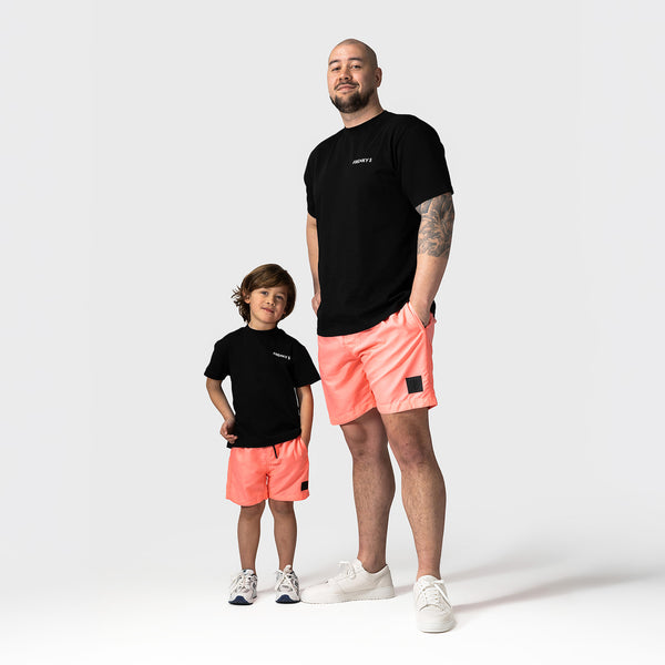 vader en zoon dragen matching neon roze zwembroeken van Frenky S bij het zwembad