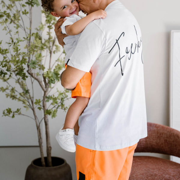 vader en zoon dragen matching neon oranje zwembroeken van Frenky S bij het zwembad