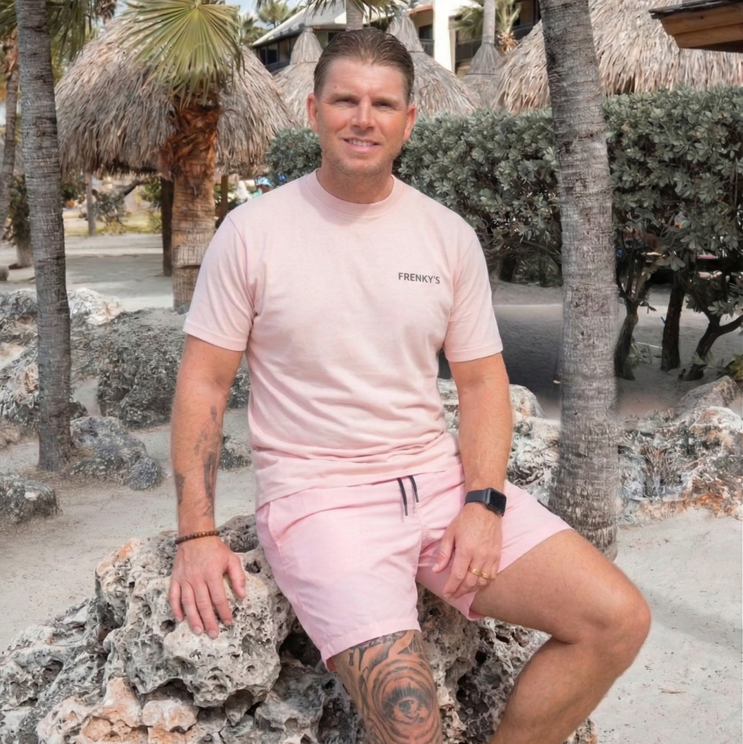 man draagt licht roze heren zwembroek van Frenky S met ritszakken op het strand