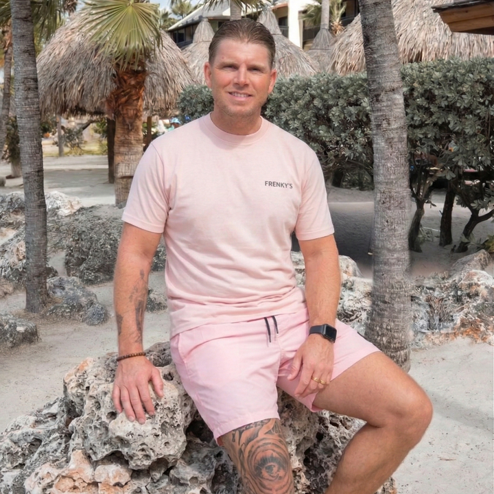 man draagt licht roze heren zwembroek van Frenky S met ritszakken op het strand