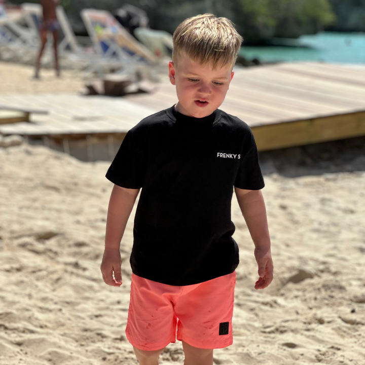 kind draagt zwart kids Travel T-shirt van Frenky S met rugprint vliegtuigraampje met uitzicht op Koh Samui