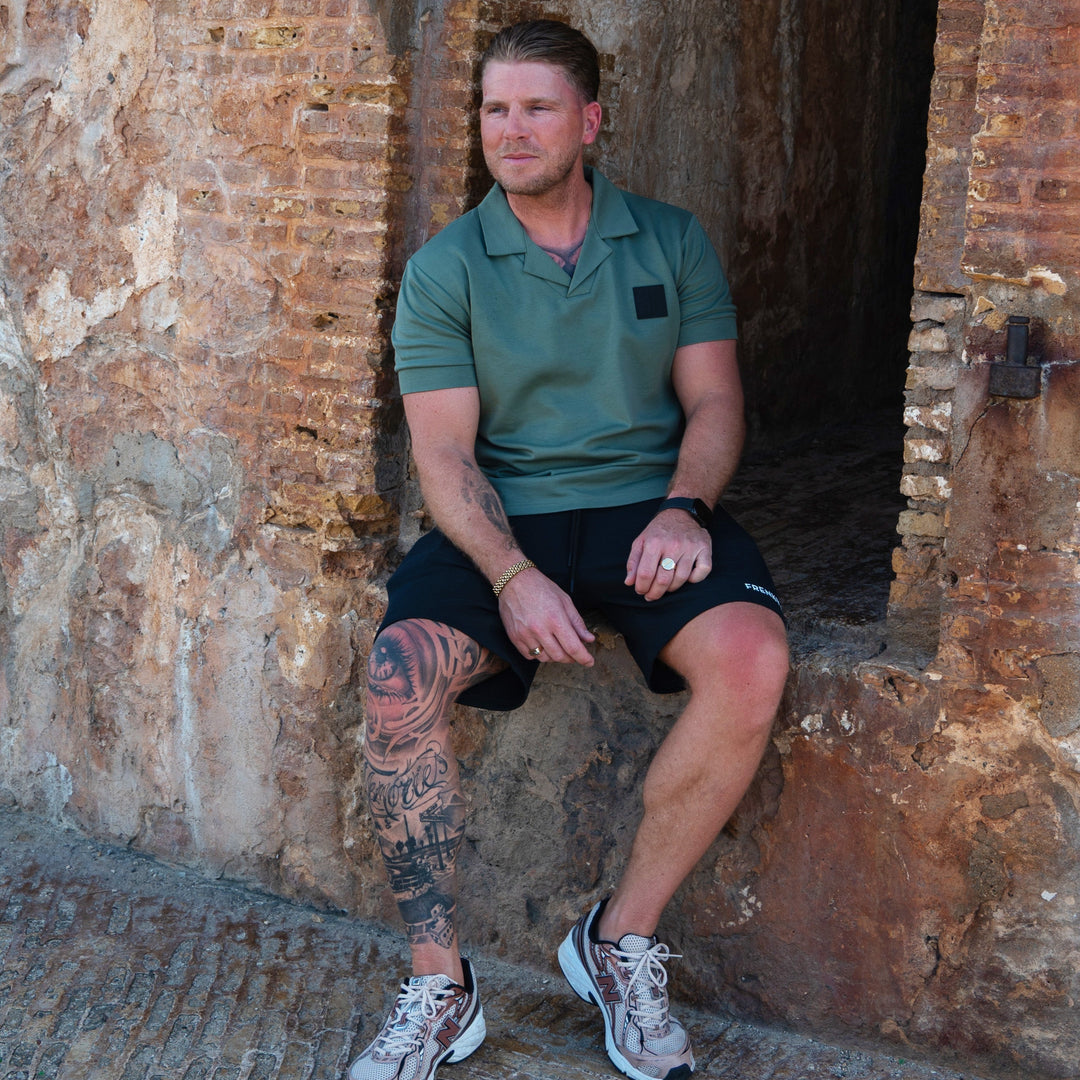 man draagt groene reverse collar scuba polo van Frenky S met logo patch op de borst