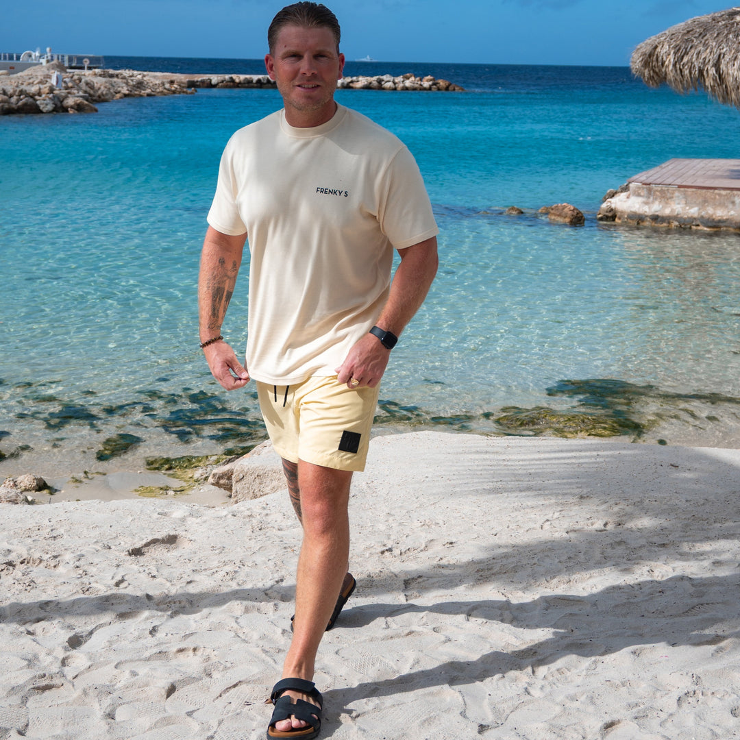man draagt gele heren zwembroek butter yellow van Frenky S met ritszakken op het strand