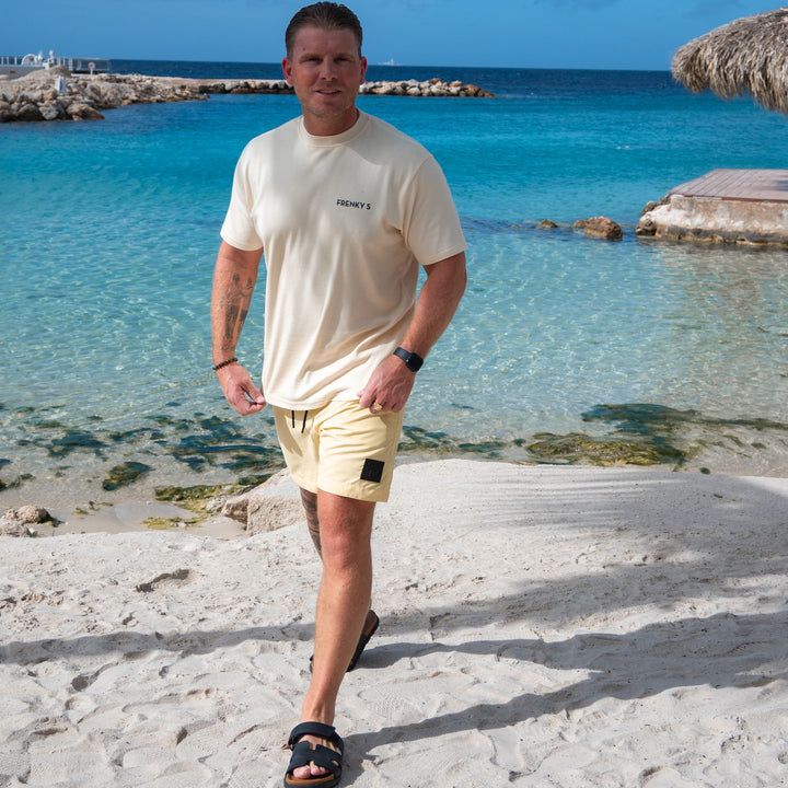 man draagt gele heren zwembroek butter yellow van Frenky S met ritszakken op het strand