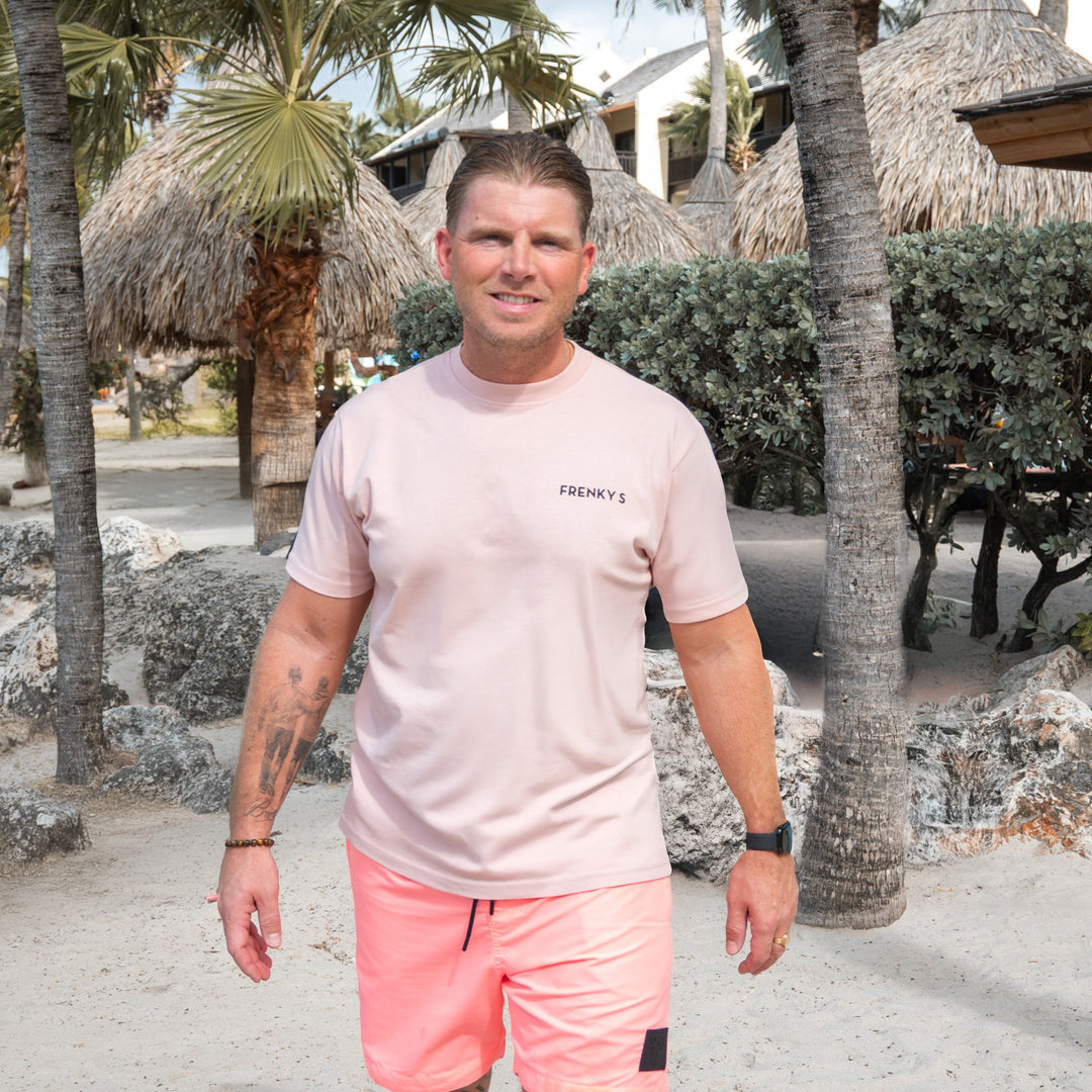 man draagt zacht roze heren T-shirt van 100% katoen met nieuw Frenky S logo op de voorkant en bekend logo op de achterkant