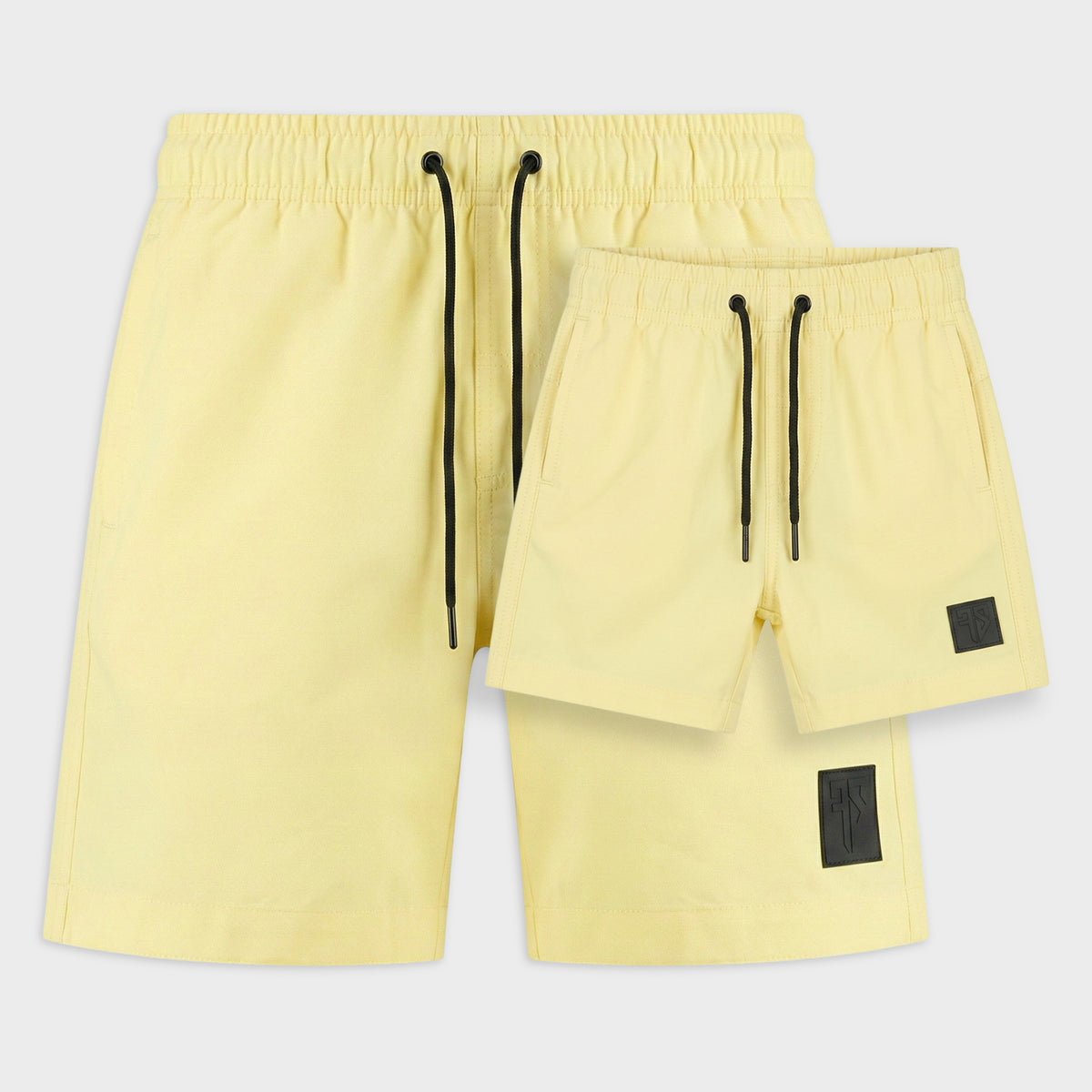 Vader en zoon in matching butter yellow zwembroeken van Frenky S op zonnig strand